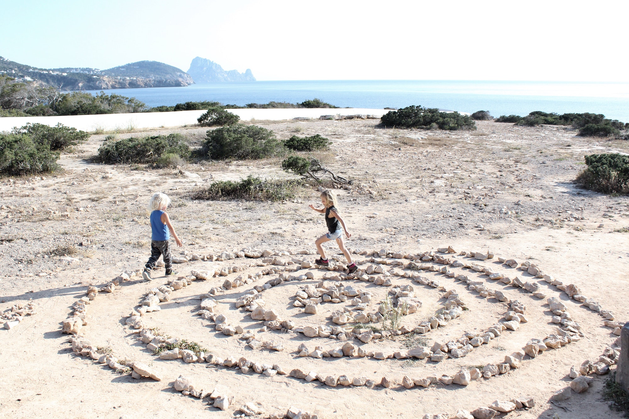 Kids running in a circle of stones